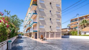 A multi-story hotel with balconies, a paved driveway, and a clear sky. - Hipocampo by Interhome (Dénia)