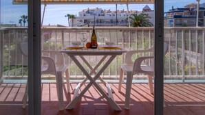 A balcony with a table set for two, a bottle of wine, and a view of buildings in the background. - Hipocampo by Interhome (Dénia)