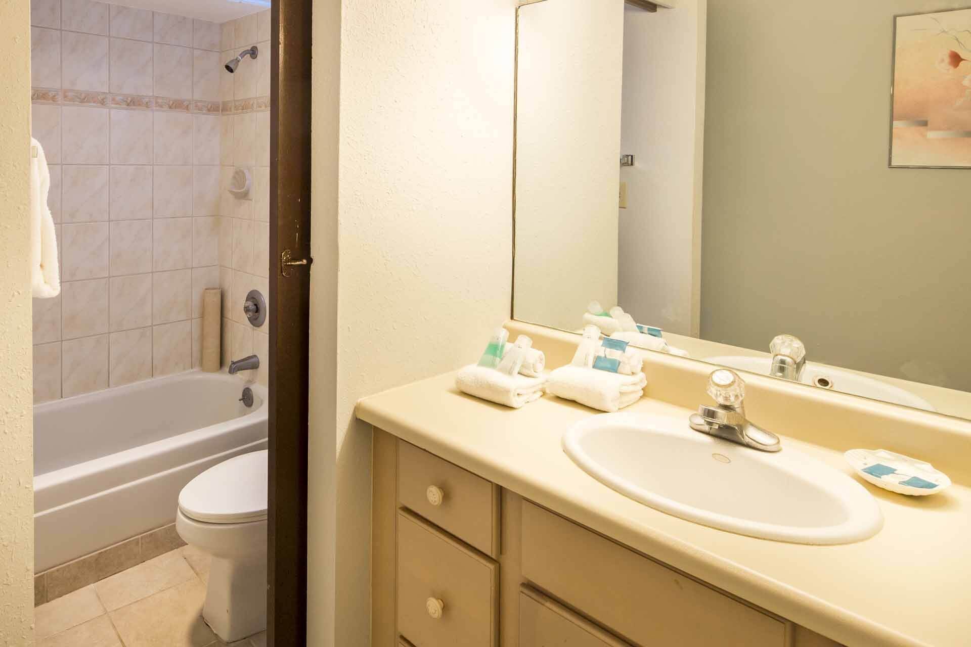 Une salle de bain équipée d’une baignoire, de toilettes, d’un lavabo et d’un miroir.