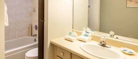 Une salle de bain équipée d’une baignoire, de toilettes, d’un lavabo et d’un miroir.