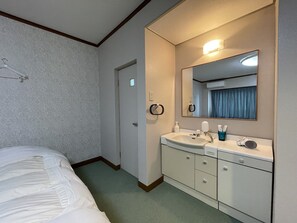 A hotel room with a bed, a bathroom with a sink, mirror, and toiletries. - Marina Hotel Kaiku (Shirahama)