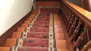 A wooden staircase with a patterned carpet and a wooden handrail. - New Remodeled Studio in Oakland's Dimond District (Oakland)