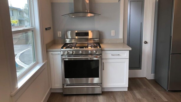 A compact kitchen with a stove, oven, microwave, and stainless steel refrigerator. - New Remodeled Studio in Oakland's Dimond District (Oakland)