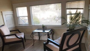 A room with two dark wooden chairs, a small glass table, and a potted plant. - New Remodeled Studio in Oakland's Dimond District (Oakland)