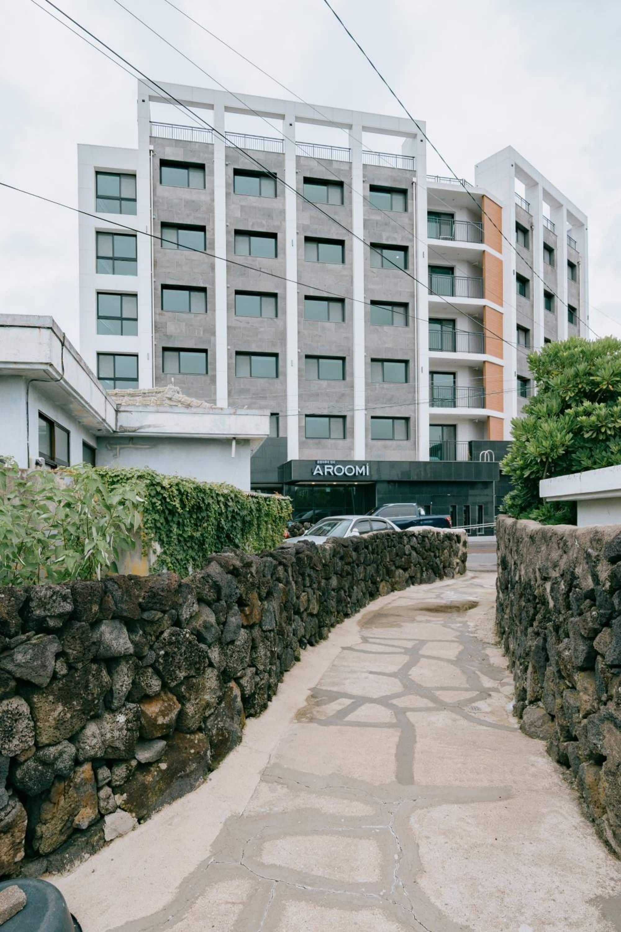 Un edificio moderno de varios pisos con un camino de piedra que lleva a la entrada.