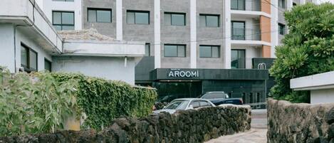 Un edificio moderno de varios pisos con un camino de piedra que lleva a la entrada.