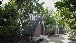 A secluded cabin with a sloped roof, surrounded by dense foliage. - Floating Sanctuary Resort Bulacan powered by Cocotel (Santa Maria)