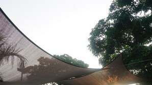 A covered outdoor area with a patterned floor, a shaded structure, and surrounding greenery. - Floating Sanctuary Resort Bulacan powered by Cocotel (Santa Maria)