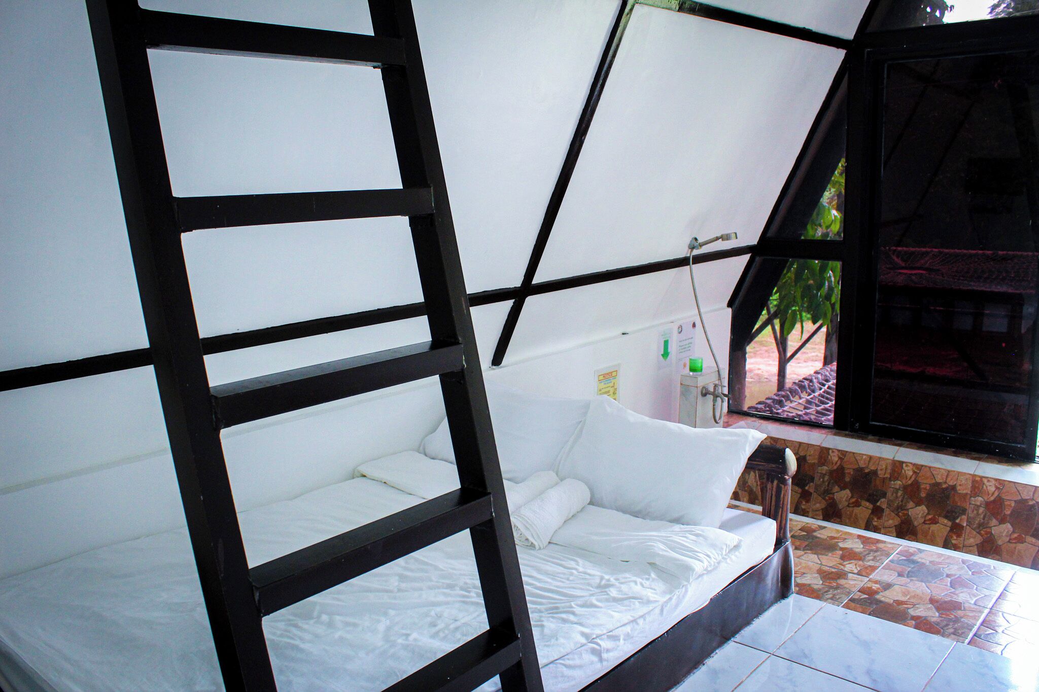 Una habitación con cama, ventana y zona de ducha.