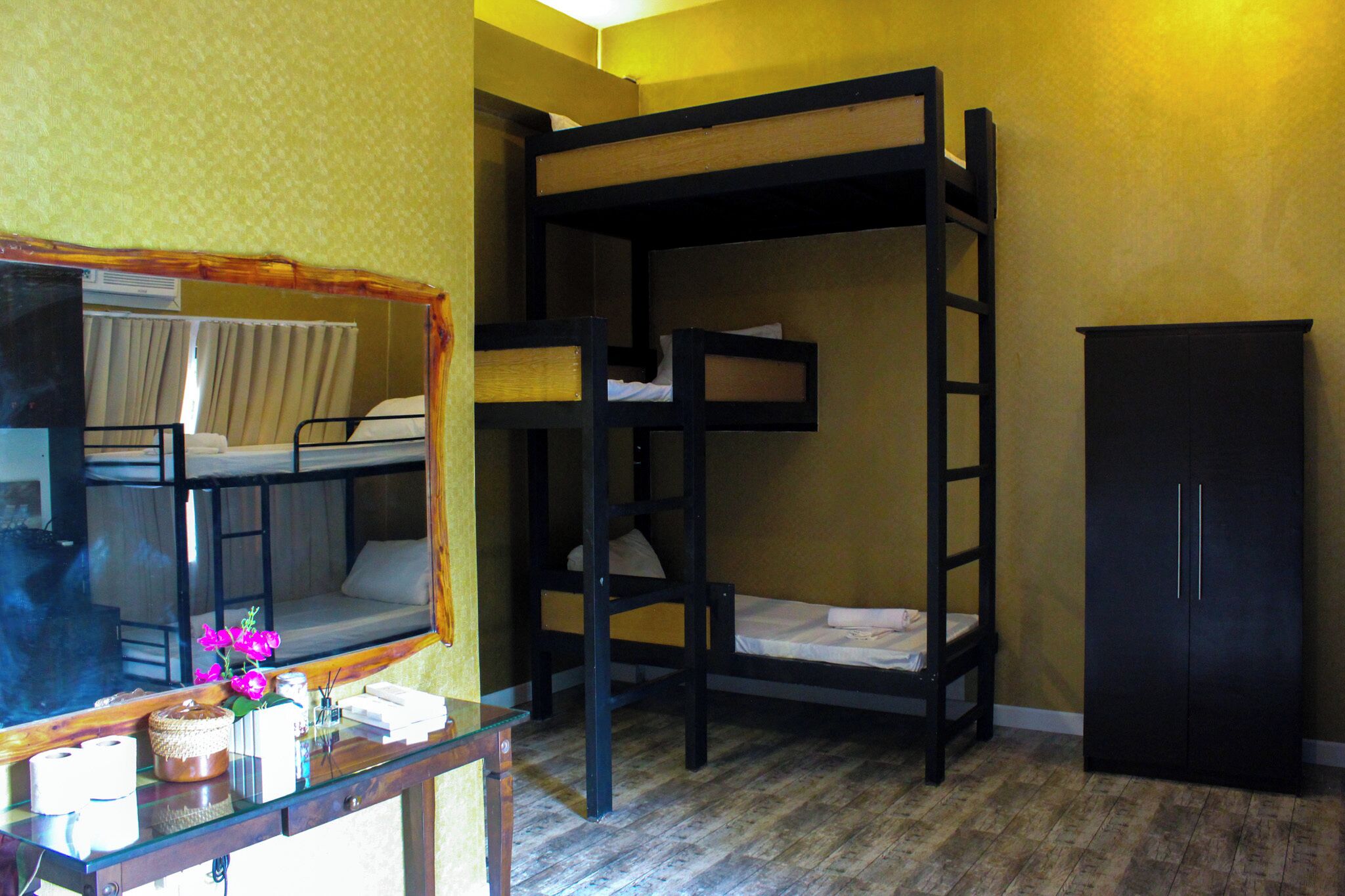 Habitación con literas, escritorio, espejo y armario.