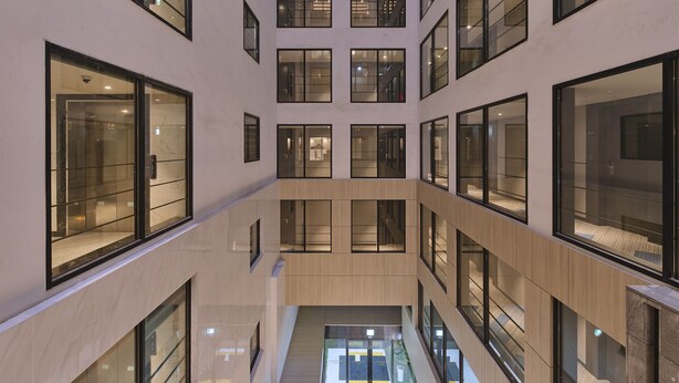 A modern building with multiple floors, large windows, and a central open space. - Jeju Grace Hotel (Seogwipo)