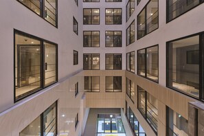 A modern building with multiple floors, large windows, and a central open space.