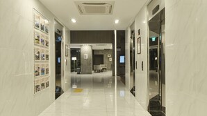 A modern hotel lobby with a clean, polished floor, a reception desk, and a seating area. - Jeju Grace Hotel (Seogwipo)
