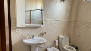A bathroom with a pedestal sink, a bidet, and a toilet. - Great value for its price (Tirana)