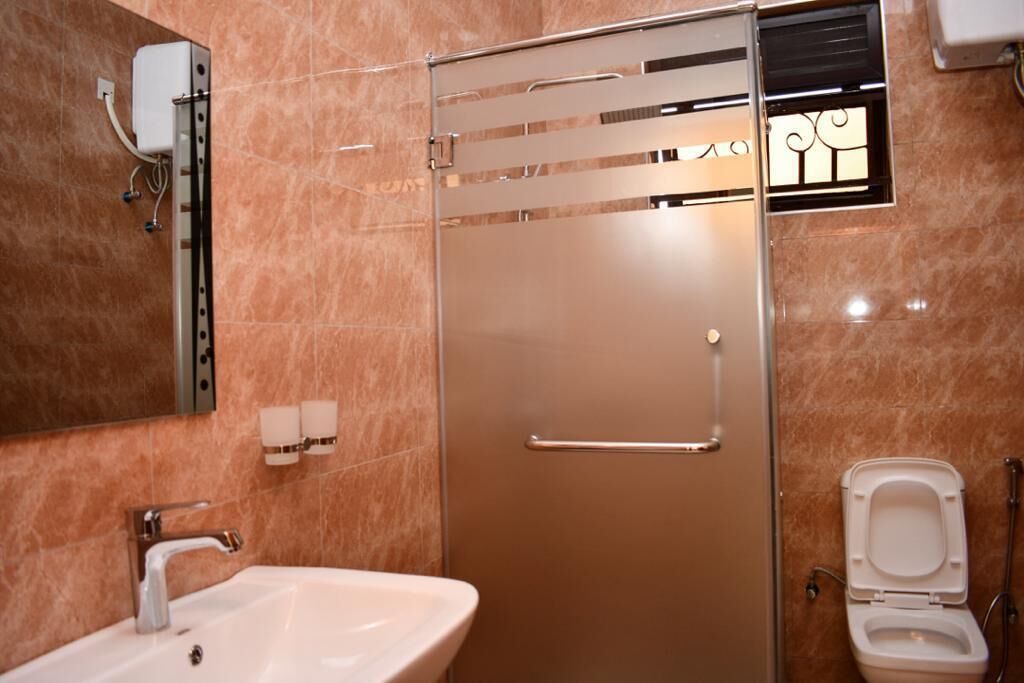 Ein Badezimmer mit Duschkabine, Waschbecken und Toilette.