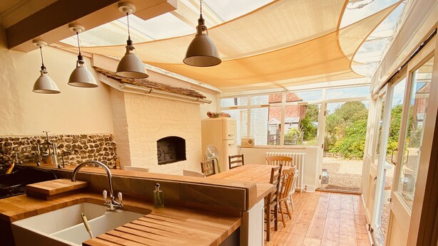 A modern kitchen with a wooden island, a built-in oven, and pendant lighting. - A Unique Tudor Manor House dating from 1547 (Painters Forstal)