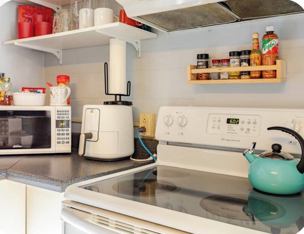 A kitchen with a microwave, toaster, and stove.