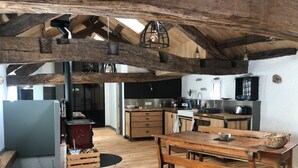 Eine rustikale Küche mit Holzbalken, einem Holztisch und einem eingebauten Herd.