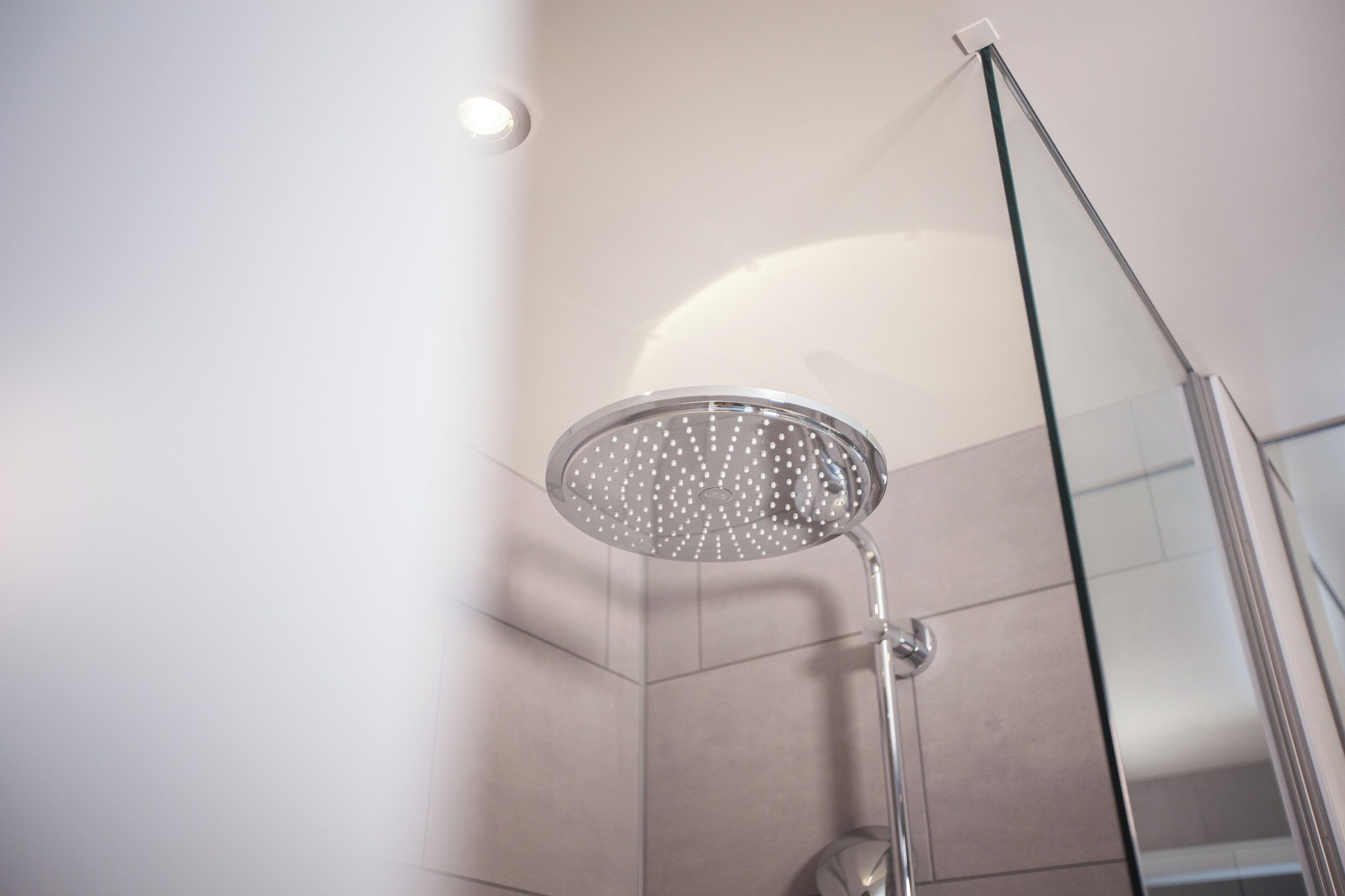 A modern shower with a glass enclosure and a handheld showerhead.