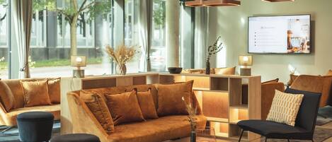 A modern lobby with a sofa, chairs, and a coffee table.