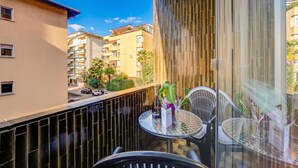 A balcony with a table, chairs, and a bottle of champagne. - Sunlight - 150m From the Lake (Lugano)