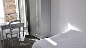 A bedroom with a bed, a desk, and a wardrobe. - Port Royal Hotel (Paris)