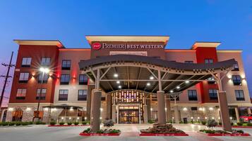 A hotel entrance with a covered walkway, signage for 'Premier Best Western', and 'No Parking Fire Lane' signs.