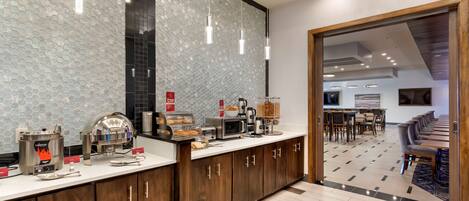 Una cocina moderna con barra desayunadora, equipada con cafetera, tostadora y hervidor.
