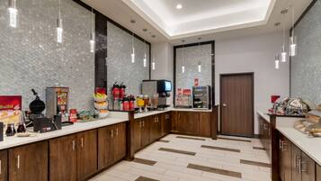 A modern kitchen with wooden cabinets, a white countertop, and hanging pendant lights.