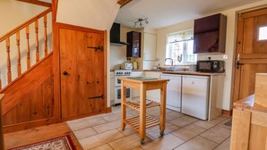 Une cuisine avec des meubles de rangement en bois, une cuisinière, un four à micro-ondes et un lave-vaisselle.