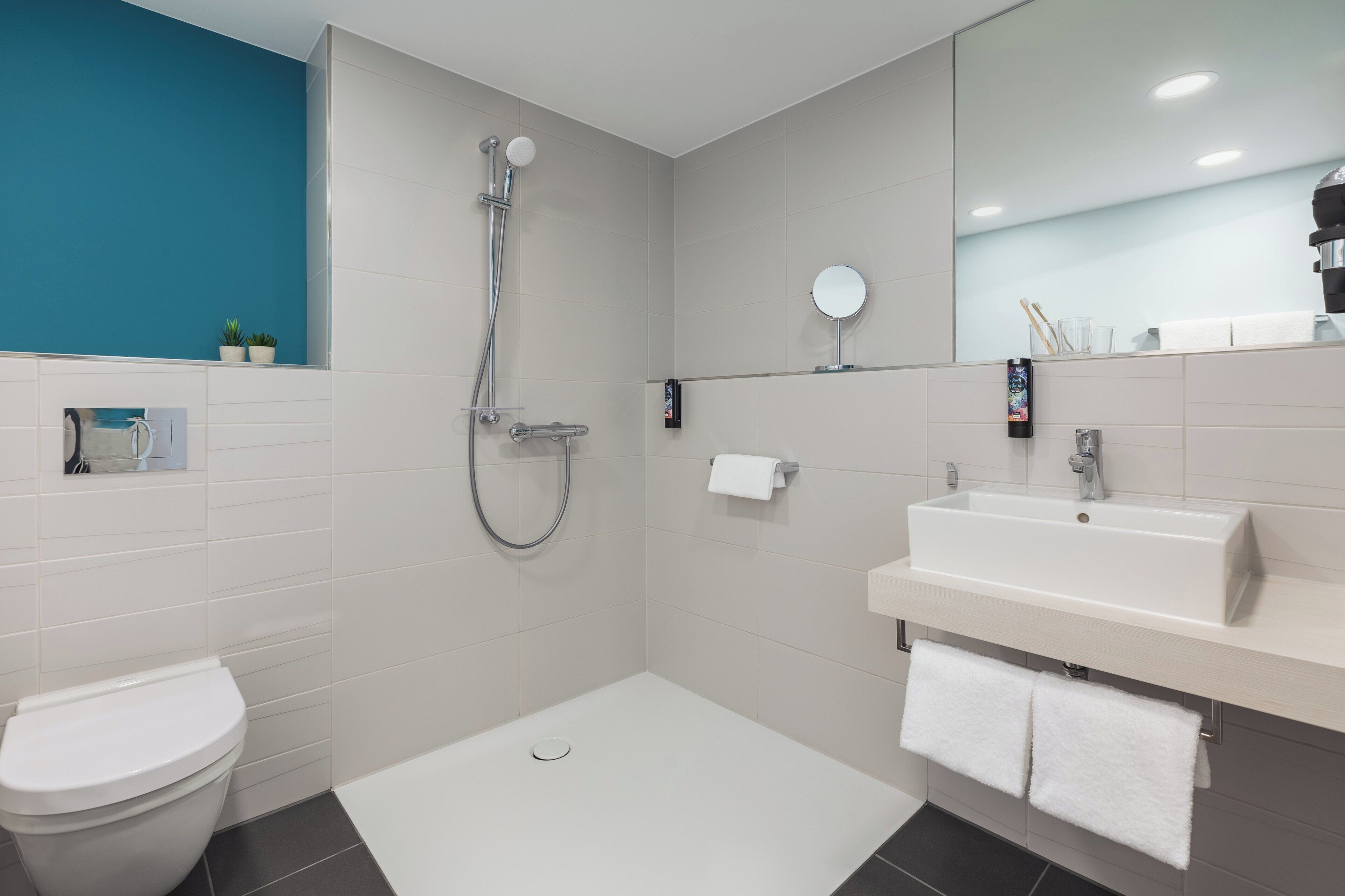 Un baño moderno con ducha, inodoro y lavamanos.