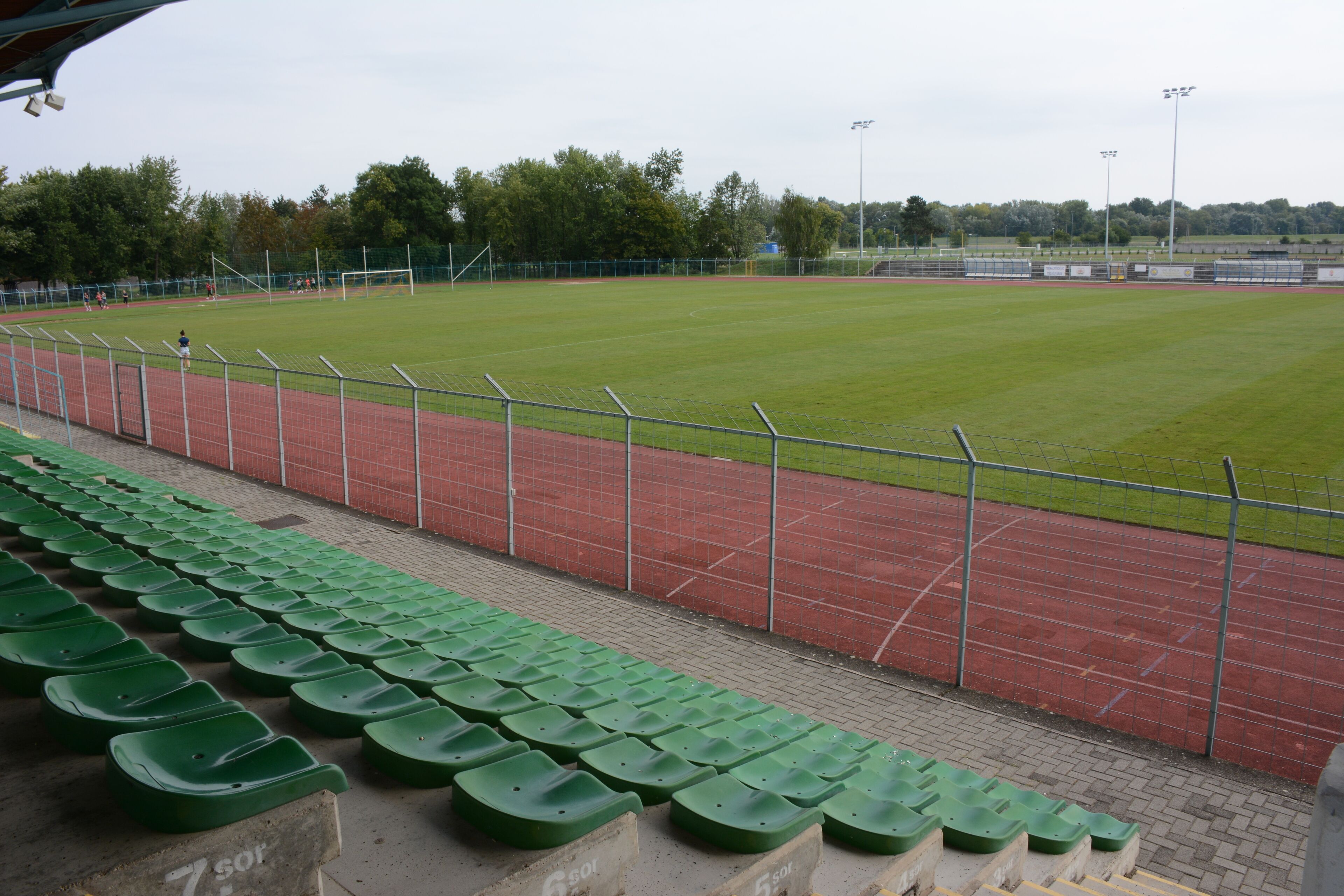 A stadium with green seating and a running track.
