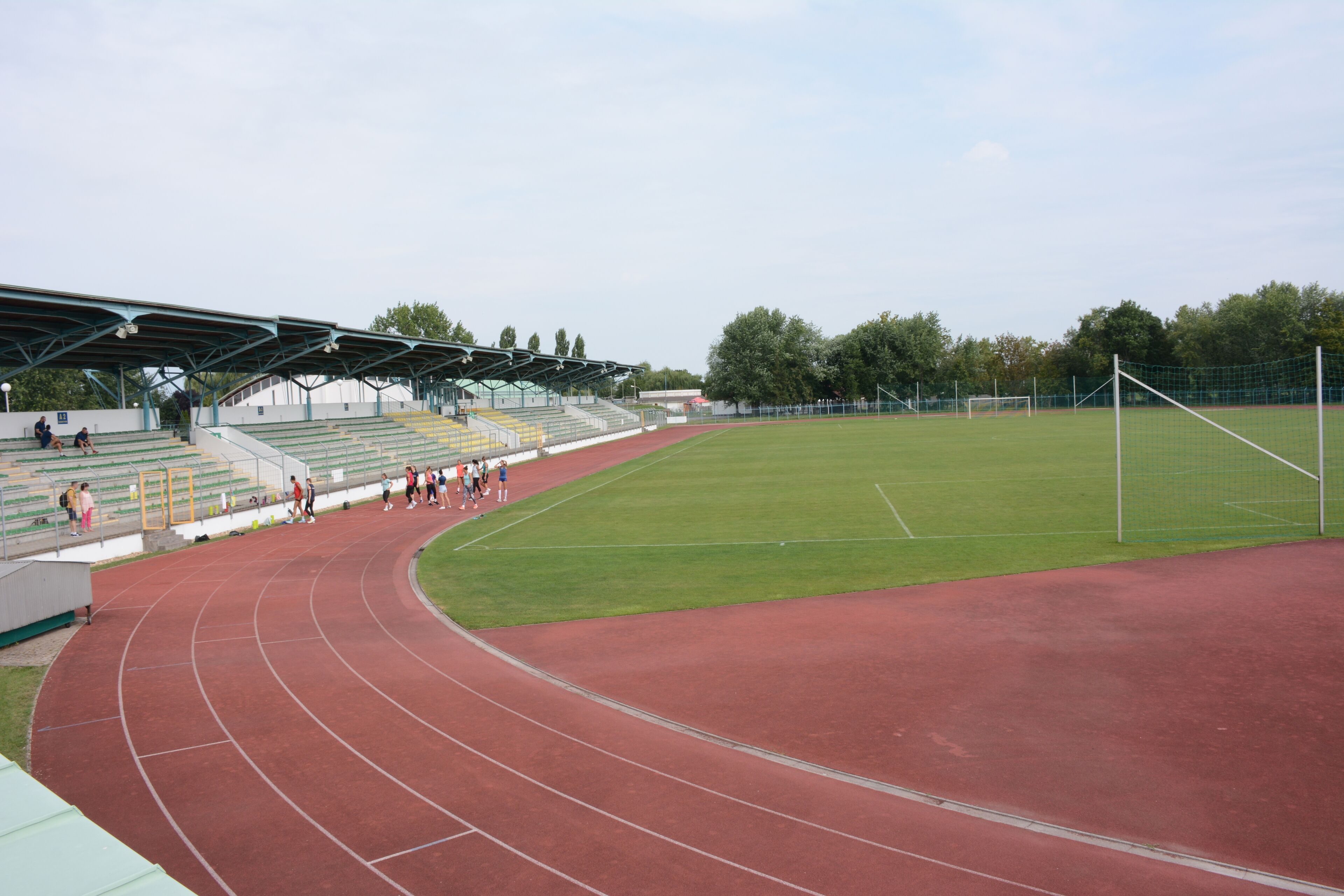 A stadium with a running track, seating areas, and a soccer field.