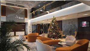 Un vestíbulo moderno con un árbol de Navidad, asientos cómodos y una recepción.