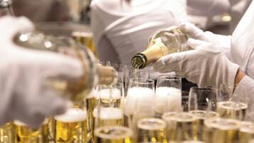 Une personne qui verse un liquide dans plusieurs verres.