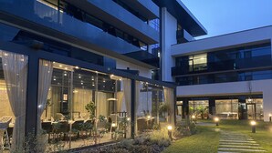 Un edificio moderno con amplios ventanales de vidrio y un césped cuidado.