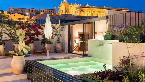 A rooftop terrace with a hot tub, seating area, and potted plants. - Exclusive property with terrace and plunge-pool, Noto, Sicily (Noto)