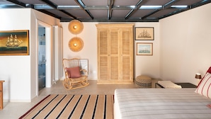 A bedroom with a bed, a rocking chair, a wardrobe, and two wall-mounted lamps. - Exclusive property with terrace and plunge-pool, Noto, Sicily (Noto)