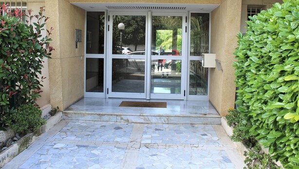 L’entrée d’un immeuble, sur laquelle on peut lire l’inscription « LE PERSEPOLIS » et l’adresse « 18 B ».