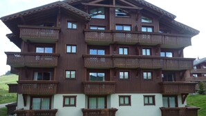 Un edificio de madera de varios pisos con balcones y ventanas grandes.