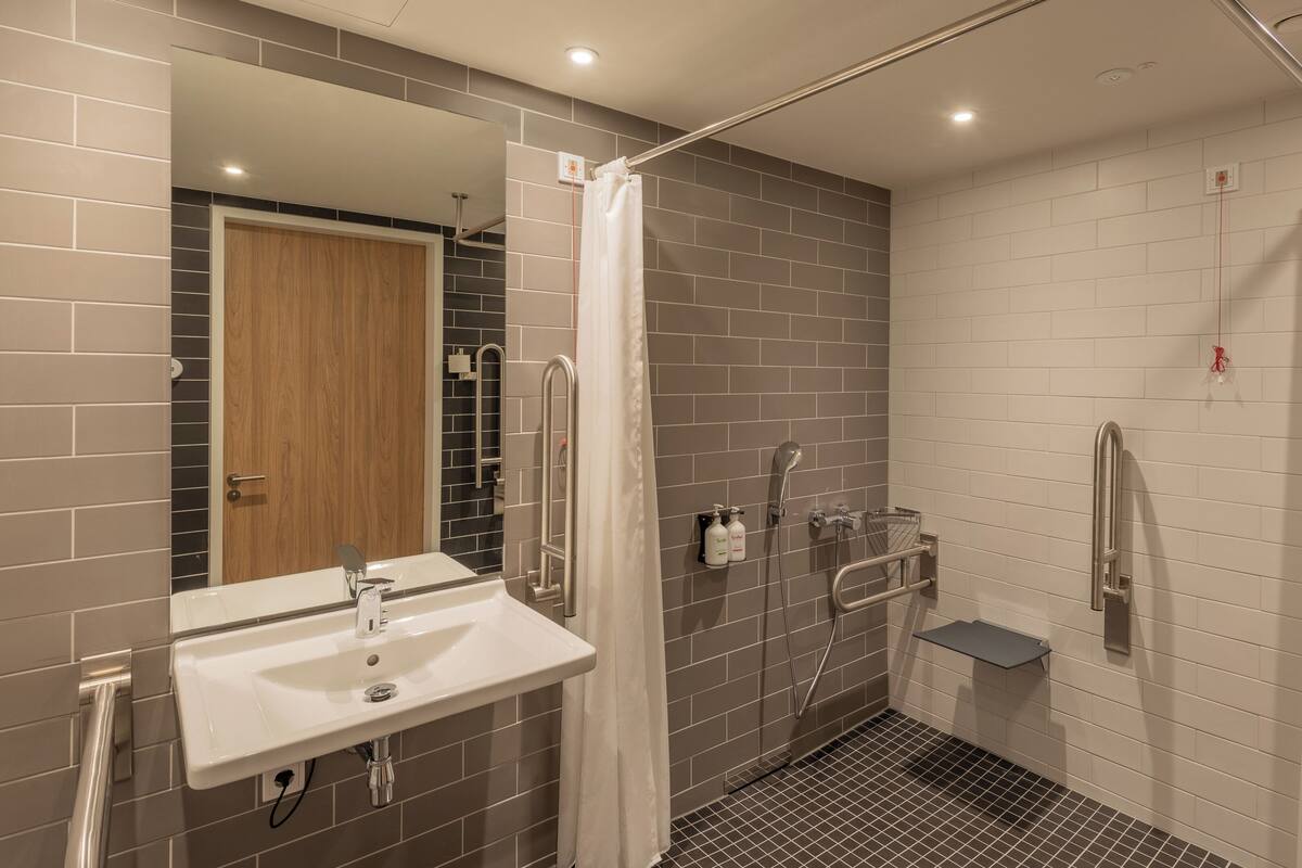 A modern bathroom with a shower, toilet, and sink.
