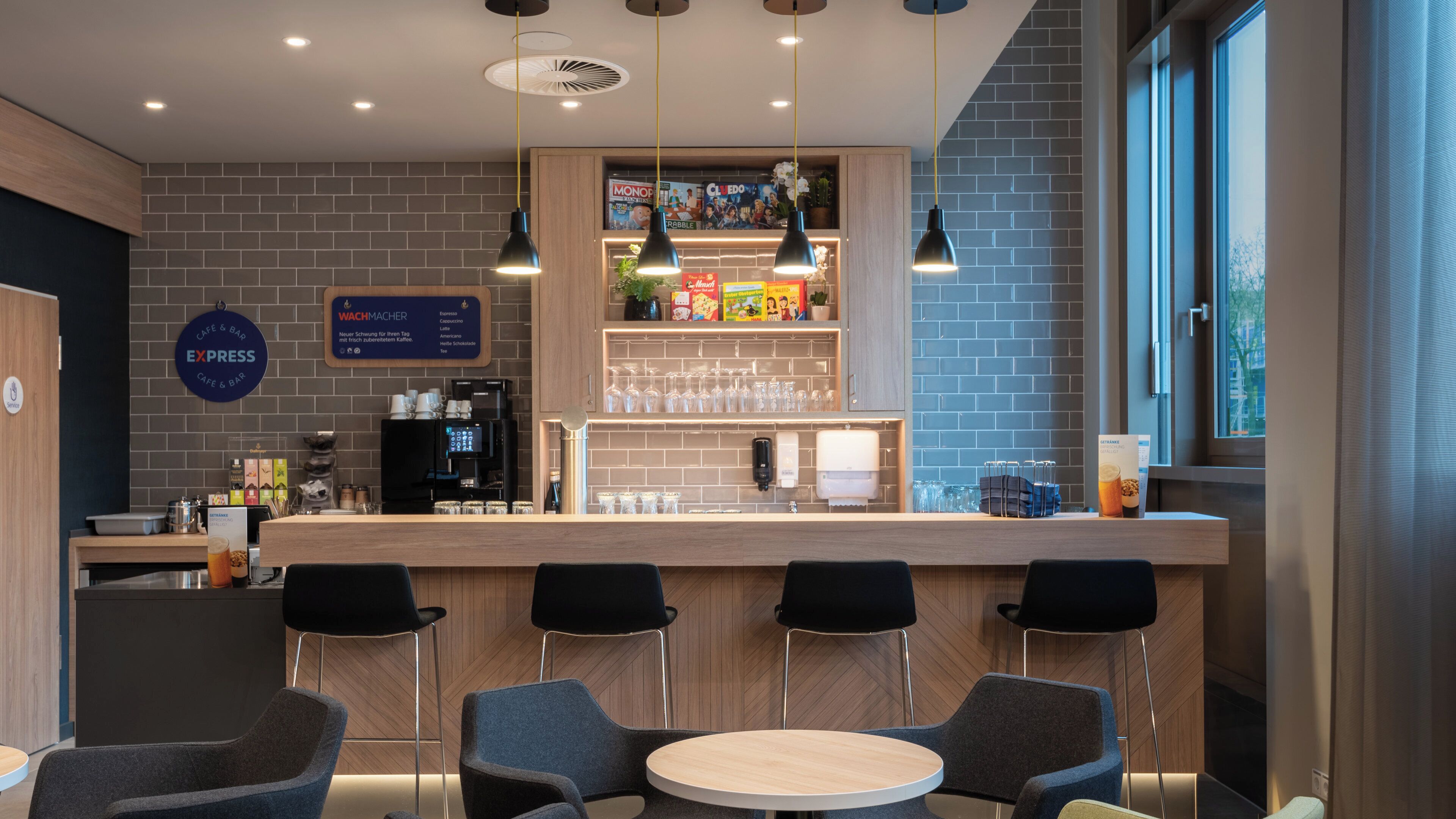 A modern cafe with a bar area, seating, and a menu board.