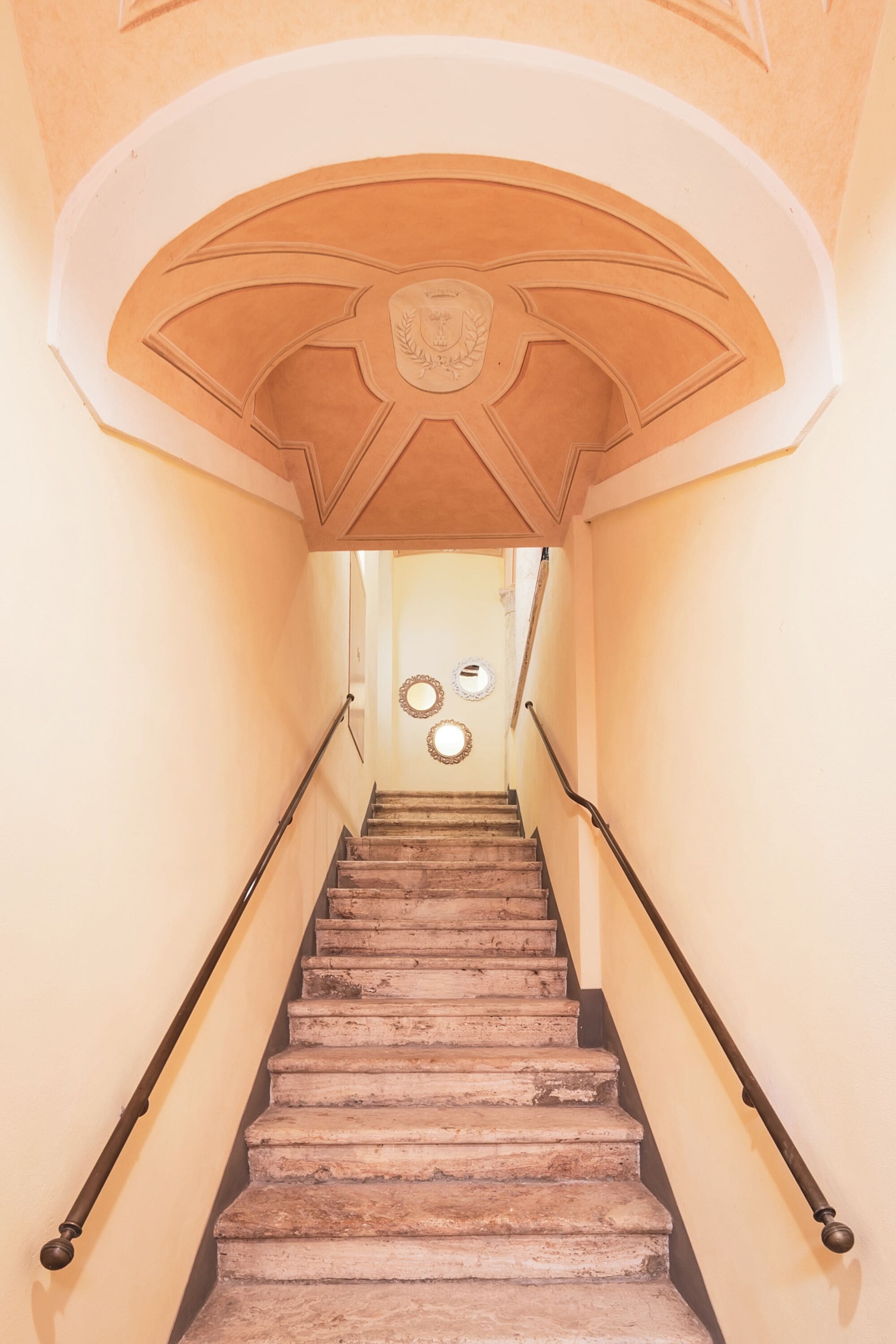 Eine Treppe mit einem Holzgeländer und einer beigen Wand.