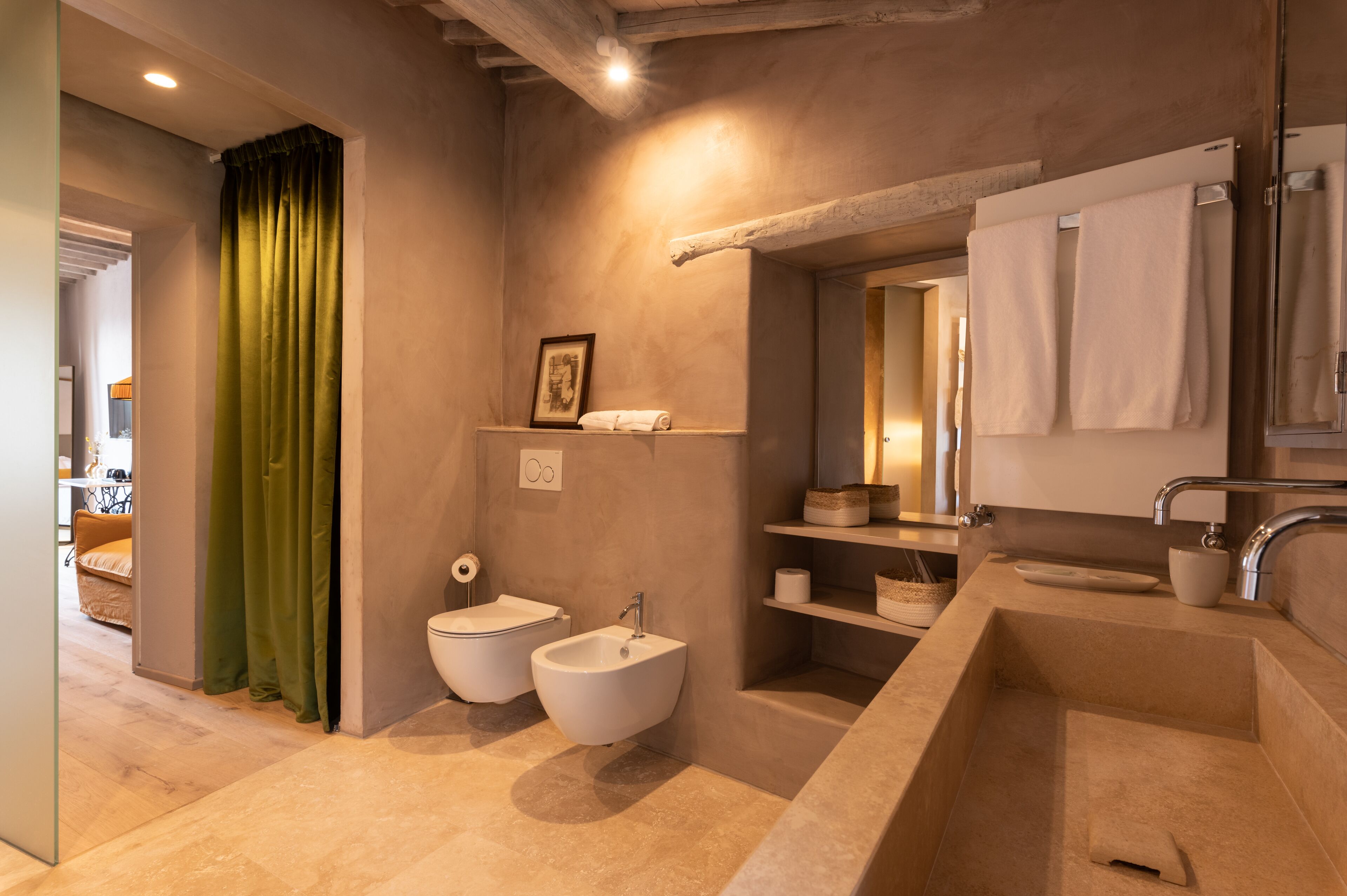 A modern bathroom with a large bathtub, two sinks, and a bidet.
