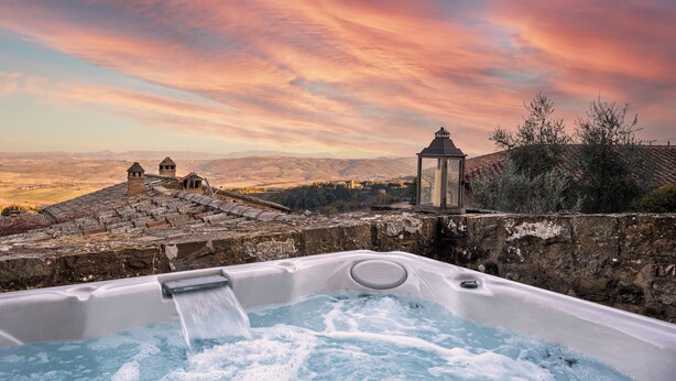 Un jacuzzi con vistas a un edificio histórico y montañas.