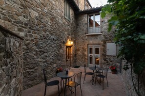 Enjoy a tranquil dining experience in this charming courtyard with a table and chairs surrounded by lush greenery.
