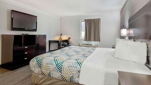 A hotel room with a bed, a desk, a television, and a wardrobe. - Motel6 Bartlesville OK (Bartlesville)