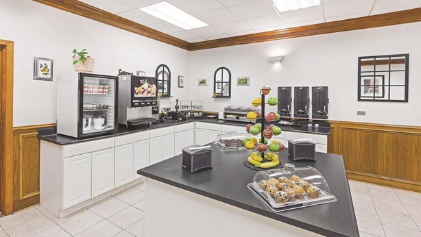 A modern kitchen with a central island, a coffee machine, and a fruit display. - Motel6 Bartlesville OK (Bartlesville)