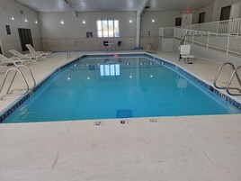 Una piscina interior con agua cristalina, marcas de profundidad y borde de azulejos.