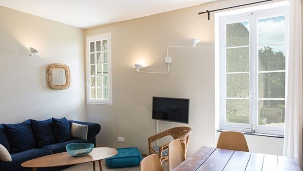 Un salon confortable avec un canapé, une table et un téléviseur.